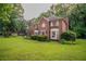 Two-story brick home with lush green lawn and mature trees at 214 Jamestown Ave, Jonesboro, GA 30236