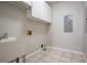 Functional laundry room with a utility sink, tile flooring, and ample storage cabinets at 214 Jamestown Ave, Jonesboro, GA 30236