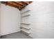 Unfinished basement features white cinderblock walls and a simple shelving unit for storage at 3322 Northcrest Rd # A, Atlanta, GA 30340