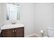Simple bathroom featuring a vanity with dark wood cabinets, toilet, and a plain, rectangular mirror at 3322 Northcrest Rd # A, Atlanta, GA 30340