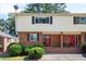 Charming brick townhome with well-maintained landscaping, a red door, and inviting curb appeal at 3322 Northcrest Rd # A, Atlanta, GA 30340