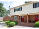 Charming brick townhome with well-maintained landscaping, a red door, and inviting curb appeal at 3322 Northcrest Rd # A, Atlanta, GA 30340