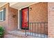 Inviting front porch featuring brick accents, a red door and black trim, providing a warm welcome to the residence at 3322 Northcrest Rd # A, Atlanta, GA 30340