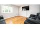 Bright living room boasting hardwood floors, large window, and sleek wall-mounted TV, creating a cozy and modern space at 3322 Northcrest Rd # A, Atlanta, GA 30340