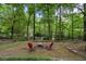 Secluded backyard fire pit area with two red Adirondack chairs amid towering trees at 905 Stovall Ne Blvd, Atlanta, GA 30319