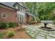 Beautiful backyard featuring a brick home, stone pathway, lush landscaping, and decorative fountain at 905 Stovall Ne Blvd, Atlanta, GA 30319