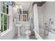 Bright bathroom with white subway tile, wainscotting, and a clawfoot bathtub at 905 Stovall Ne Blvd, Atlanta, GA 30319