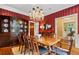 Dining room featuring a large wood table and chairs beneath a decorative chandelier, with red striped wallpaper at 905 Stovall Ne Blvd, Atlanta, GA 30319