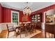 Formal dining room with a large wooden table, china cabinet, and bright red striped walls for a dramatic effect at 905 Stovall Ne Blvd, Atlanta, GA 30319