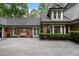 Well-maintained brick house featuring a black roof, trimmed hedges and paved driveway at 905 Stovall Ne Blvd, Atlanta, GA 30319