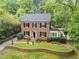 Charming two-story brick home with lush landscaping, a manicured lawn, and mature trees at 905 Stovall Ne Blvd, Atlanta, GA 30319