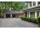 Spacious three car garage with black doors and a paved driveway on a large lot at 905 Stovall Ne Blvd, Atlanta, GA 30319