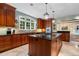 Open kitchen with tile flooring, dark wood cabinets, granite counters, and a central island with a cooktop at 905 Stovall Ne Blvd, Atlanta, GA 30319