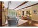 Bright living room featuring hardwood floors, fireplace, beamed ceilings and French doors to the yard at 905 Stovall Ne Blvd, Atlanta, GA 30319