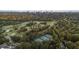 Overhead view of tennis courts and a golf course surrounded by lush greenery and a cityscape backdrop at 905 Stovall Ne Blvd, Atlanta, GA 30319
