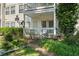 Inviting condo exterior featuring a covered porch, white railing, and lush landscaping, perfect for relaxing outdoors at 1364 Keys Crossing Ne Dr, Atlanta, GA 30319