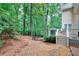 Backyard featuring a deck with grill, stone steps leading into the mature trees, and metal fence at 1850 Noblin Ridge Way, Duluth, GA 30097