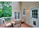 Back deck with a table and chairs, french doors leading indoors and a view of the trees at 1850 Noblin Ridge Way, Duluth, GA 30097