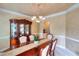 Elegant dining room with decorative chandelier, built-in display cabinet, and wall details at 1850 Noblin Ridge Way, Duluth, GA 30097