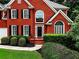 Close up shot of a brick home featuring a manicured lawn and mature landscaping at 1850 Noblin Ridge Way, Duluth, GA 30097