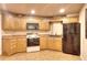 Kitchen features wood cabinetry, a black fridge, and stainless steel appliances at 1850 Noblin Ridge Way, Duluth, GA 30097