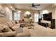 Spacious living room with plush seating, ceiling fan, and large windows with natural light at 1850 Noblin Ridge Way, Duluth, GA 30097