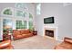 Bright living room with large windows, fireplace, and comfortable leather seating at 1850 Noblin Ridge Way, Duluth, GA 30097