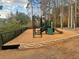 Community playground with climbable structures and a slide, set in a wooded area surrounded by nature at 1850 Noblin Ridge Way, Duluth, GA 30097