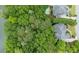 Overhead view of a home's roof and backyard pool surrounded by lush greenery near a lake at 314 Caruso Ct, Sandy Springs, GA 30350