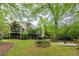 Spacious backyard featuring a well-manicured lawn, firepit, and brick home with balconies at 314 Caruso Ct, Sandy Springs, GA 30350