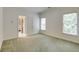 Spacious bedroom with natural light, green carpet, and view into an ensuite bathroom at 314 Caruso Ct, Sandy Springs, GA 30350