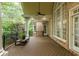 Spacious covered deck with brick accents, columns, and iron railing overlooking lush greenery at 314 Caruso Ct, Sandy Springs, GA 30350