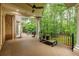 Covered deck with brick accents, ceiling fan, columns, and views of the lush greenery and wooded yard at 314 Caruso Ct, Sandy Springs, GA 30350