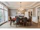 Formal dining room boasts wainscoting, chandelier lighting, large windows, and a wood table with chairs at 314 Caruso Ct, Sandy Springs, GA 30350