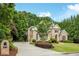 Stately brick home with mature trees, lush landscaping, and a circular driveway at 314 Caruso Ct, Sandy Springs, GA 30350