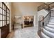 Grand foyer with travertine floors, curved staircase, and views into the dining room at 314 Caruso Ct, Sandy Springs, GA 30350