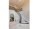 Elegant foyer featuring a curved staircase with iron railings and travertine tile flooring at 314 Caruso Ct, Sandy Springs, GA 30350