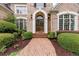 Inviting brick walkway leads to an elegant arched entryway with sidelights and manicured landscaping at 314 Caruso Ct, Sandy Springs, GA 30350