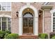 Close-up of the double wooden front door with sidelights, arched entrance, and brick facade at 314 Caruso Ct, Sandy Springs, GA 30350