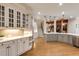 View of a large, open kitchen with white cabinets, hardwood flooring, and stainless steel appliances at 314 Caruso Ct, Sandy Springs, GA 30350