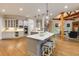 Wide angle view of a modern kitchen featuring an island with seating and a view into the living room at 314 Caruso Ct, Sandy Springs, GA 30350