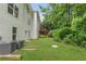 Backyard with green lawn, AC units, and wooded area at 347 Chip Rd, Stone Mountain, GA 30087
