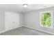 This carpeted bedroom features neutral walls, closet, and a large window at 347 Chip Rd, Stone Mountain, GA 30087