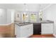 Kitchen island with granite countertop, sink, dishwasher and white cabinets on hardwood floors at 347 Chip Rd, Stone Mountain, GA 30087