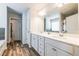 Bathroom featuring dual sink vanity, framed mirror, laminate floors, and natural light at 4700 Blake Loop, Atlanta, GA 30349