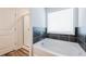 Modern bathroom with a large soaking tub, stylish tile surround, and separate shower at 4700 Blake Loop, Atlanta, GA 30349