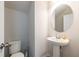 Cozy half bathroom featuring a pedestal sink, an oval mirror, and a toilet at 4700 Blake Loop, Atlanta, GA 30349