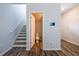 Hallway with a staircase, wood floors, neutral paint, and access to a half bathroom at 4700 Blake Loop, Atlanta, GA 30349