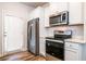 Bright kitchen with stainless steel appliances, white cabinets and wood-look flooring at 4700 Blake Loop, Atlanta, GA 30349