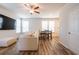 Open living room with hardwood floors, neutral paint, a ceiling fan, and a view of the kitchen at 4700 Blake Loop, Atlanta, GA 30349